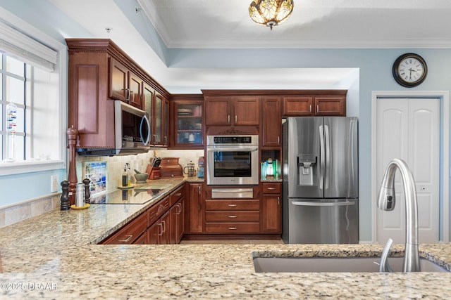 kitchen with a warming drawer, appliances with stainless steel finishes, glass insert cabinets, ornamental molding, and light stone countertops