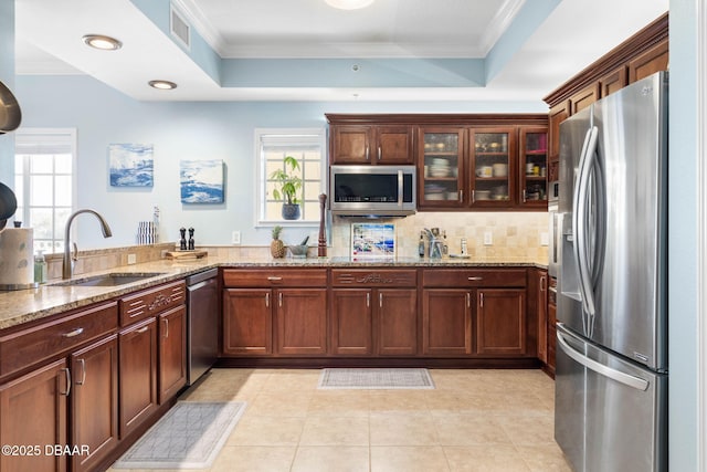 kitchen with a sink, visible vents, appliances with stainless steel finishes, plenty of natural light, and a raised ceiling