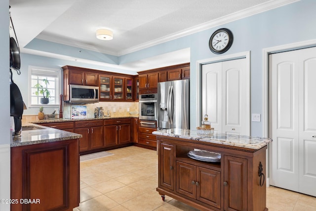 kitchen with appliances with stainless steel finishes, dark stone counters, glass insert cabinets, and backsplash