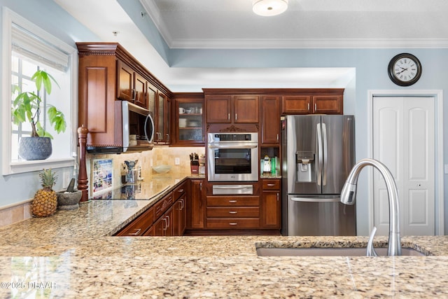 kitchen with ornamental molding, stainless steel appliances, light stone counters, and a sink