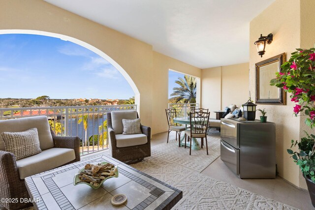 interior space with a balcony and a water view