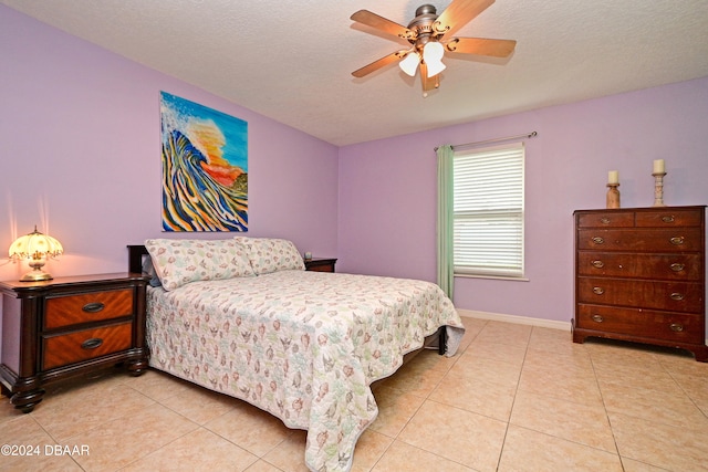 tiled bedroom with a textured ceiling and ceiling fan