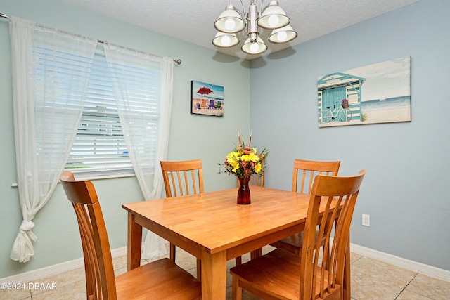 dining space featuring a textured ceiling, light tile patterned flooring, and an inviting chandelier