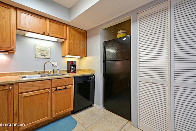 kitchen with black appliances, sink, and light tile patterned floors