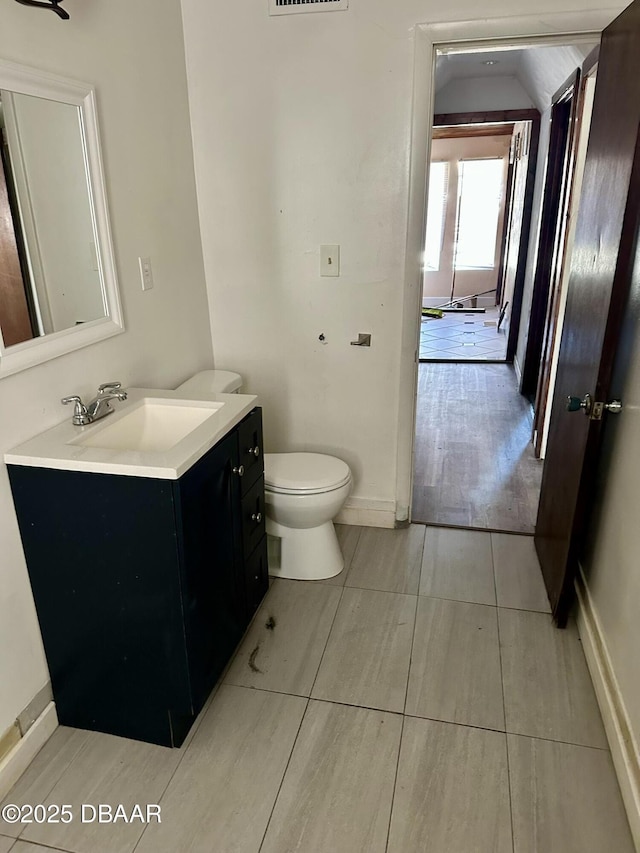 bathroom with tile patterned flooring, vanity, and toilet