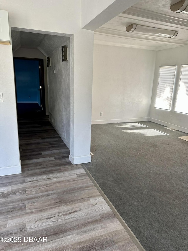 empty room with crown molding and wood-type flooring