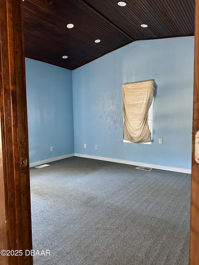 carpeted spare room featuring wood ceiling and lofted ceiling