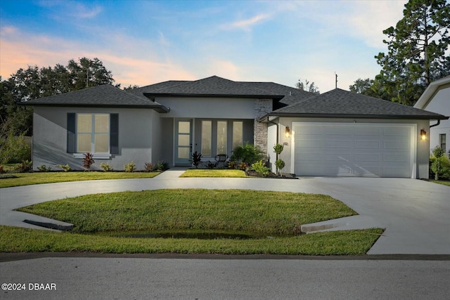 prairie-style home with a yard and a garage