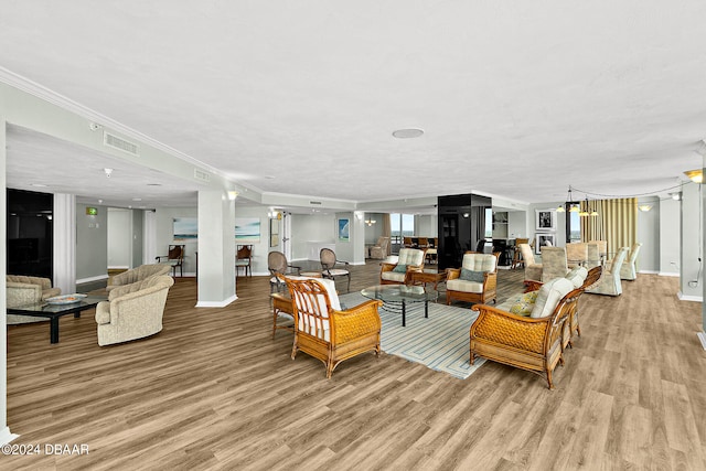 living room featuring light hardwood / wood-style floors, a textured ceiling, and crown molding