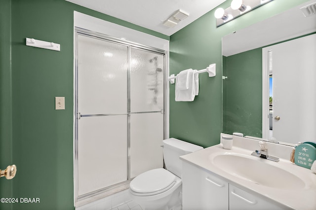 bathroom featuring vanity, tile patterned floors, toilet, and an enclosed shower