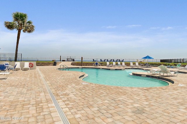 community pool with fence and a patio