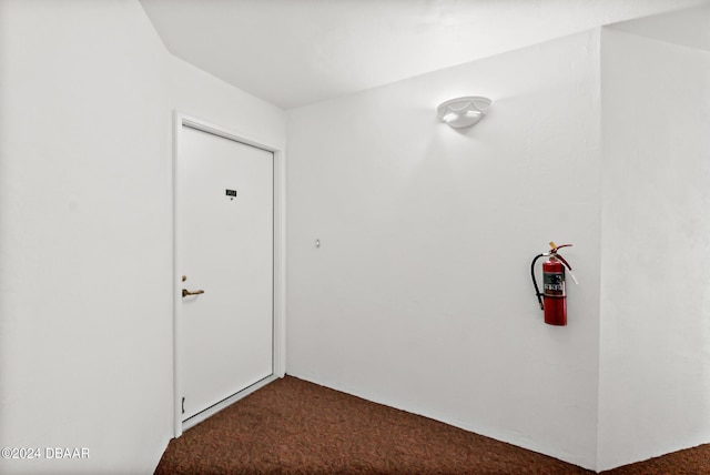 hallway featuring dark colored carpet