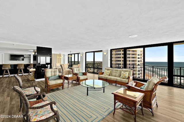 living room featuring a textured ceiling, a wall of windows, and hardwood / wood-style flooring