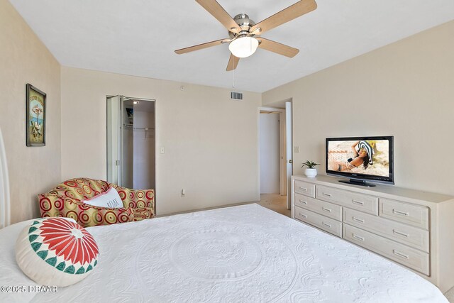 bedroom with ceiling fan and a spacious closet