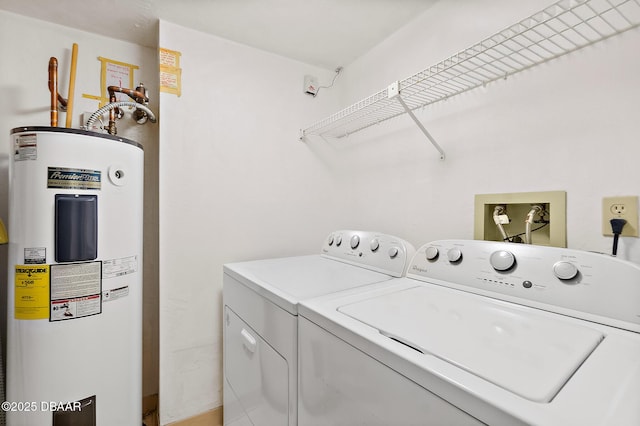 clothes washing area featuring electric water heater and independent washer and dryer