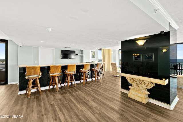 interior space with hardwood / wood-style floors and wall chimney exhaust hood