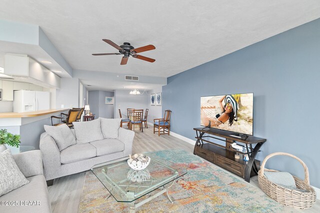 living area with ceiling fan, wood finished floors, and baseboards
