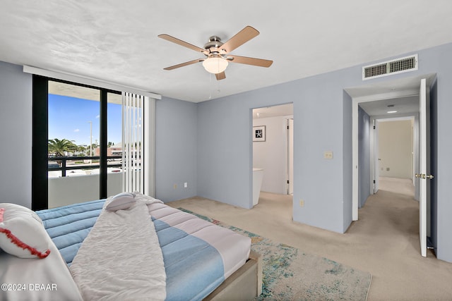 carpeted bedroom with access to outside, ceiling fan, and ensuite bath