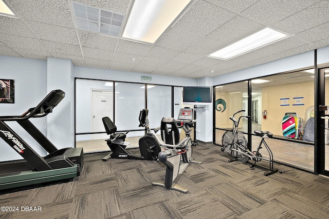 gym featuring carpet and a paneled ceiling