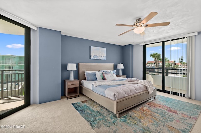 carpeted bedroom featuring ceiling fan, access to exterior, and floor to ceiling windows