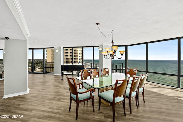 dining space featuring a chandelier, expansive windows, a water view, and wood-type flooring