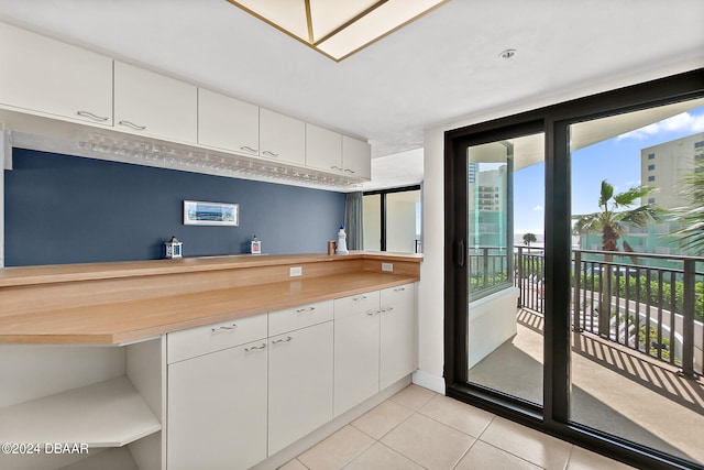 kitchen with light tile patterned flooring and white cabinetry