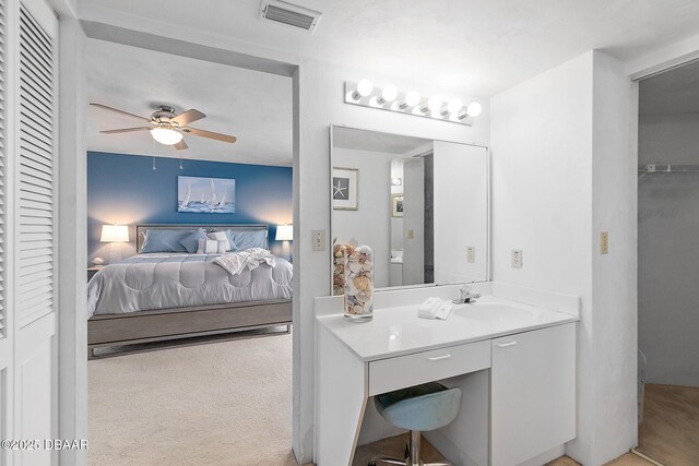 ensuite bathroom with ceiling fan and vanity