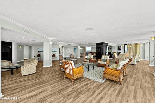 2555 S Atlantic Ave Unit 207, Daytona Beach Shores, FL 32118 - living area featuring light wood-style flooring, crown molding, baseboards, and a chandelier