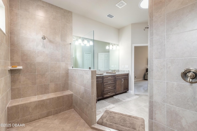 bathroom with tile patterned floors, vanity, and tiled shower