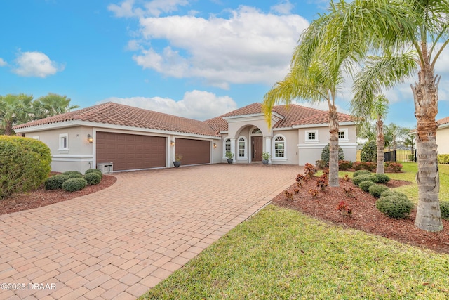 mediterranean / spanish-style home with a garage