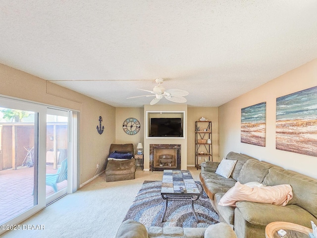 living area featuring light carpet, lofted ceiling, ceiling fan, a textured ceiling, and a fireplace