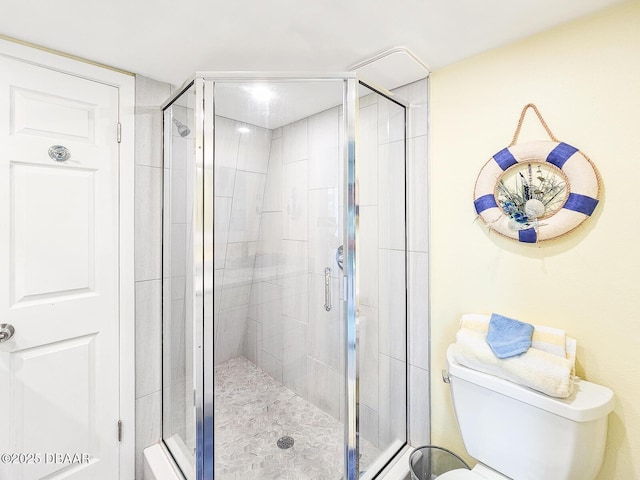 bathroom featuring a stall shower and toilet