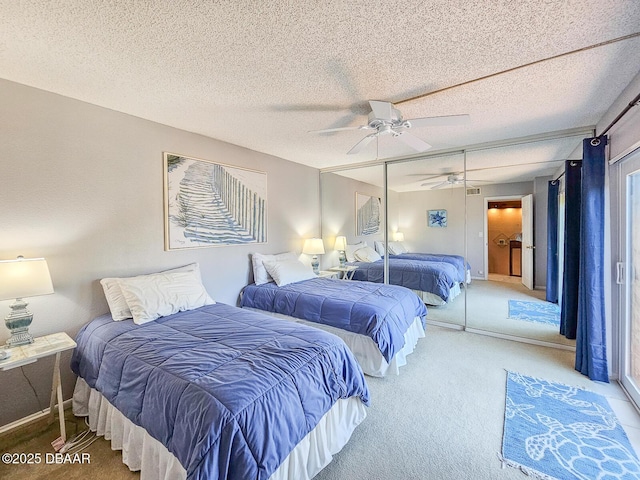 carpeted bedroom with ceiling fan, a textured ceiling, baseboards, and a closet