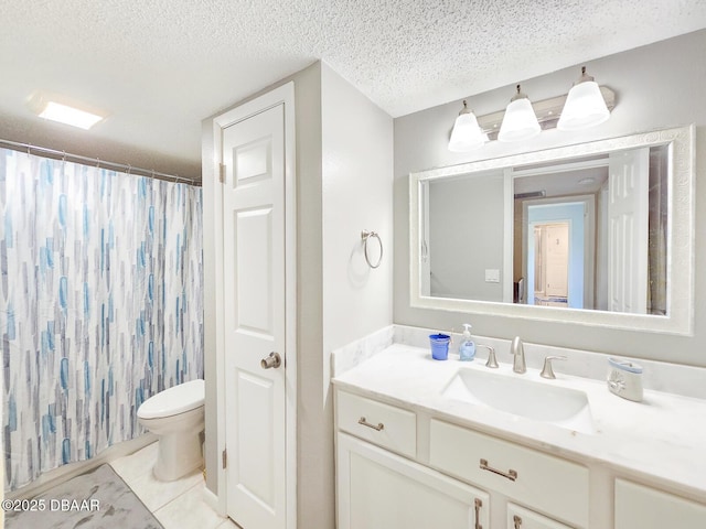 bathroom featuring toilet, vanity, a textured ceiling, and tile patterned floors