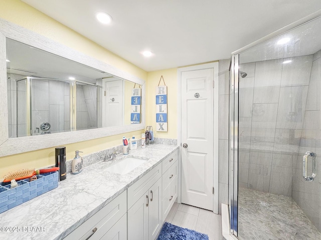 bathroom with tile patterned flooring, a shower stall, and vanity