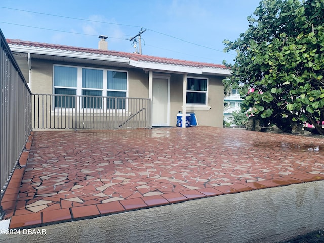 view of front of property featuring a tiled roof and stucco siding