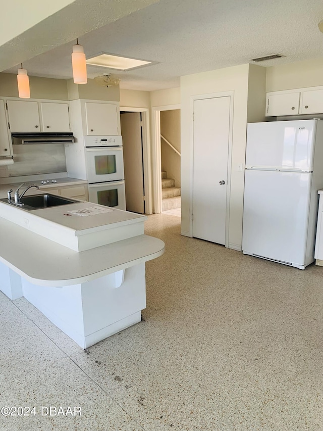 kitchen with white appliances, a sink, under cabinet range hood, white cabinetry, and light speckled floor