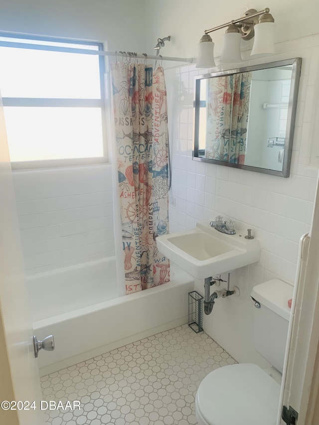 bathroom featuring tile patterned floors, shower / bath combination with curtain, toilet, and tile walls