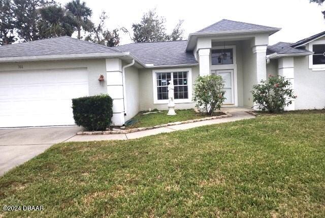 view of front of property featuring a garage and a front lawn