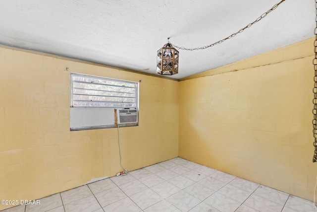 unfurnished room with cooling unit and a textured ceiling