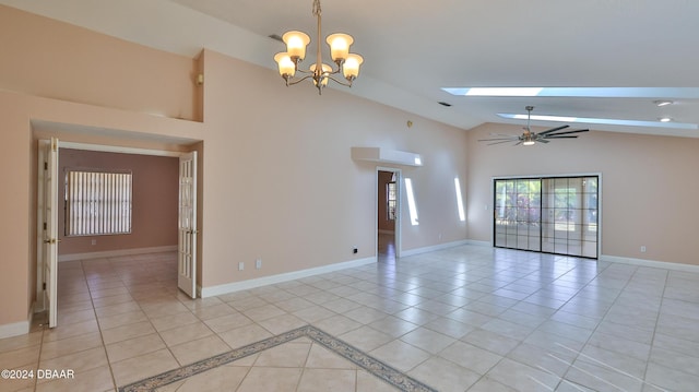 spare room featuring light tile patterned floors, high vaulted ceiling, ceiling fan with notable chandelier, a skylight, and baseboards