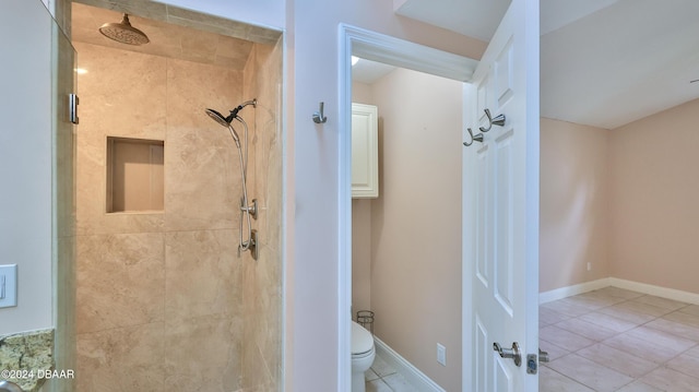 full bathroom featuring toilet, a stall shower, tile patterned flooring, and baseboards