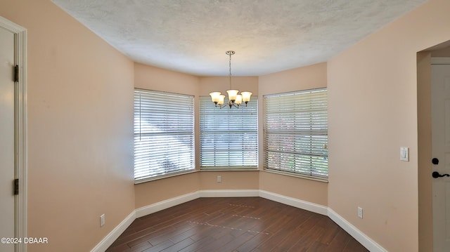 unfurnished room with dark wood-style floors, baseboards, and a textured ceiling