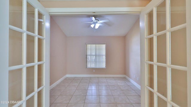 tiled spare room featuring ceiling fan, baseboards, vaulted ceiling, and french doors