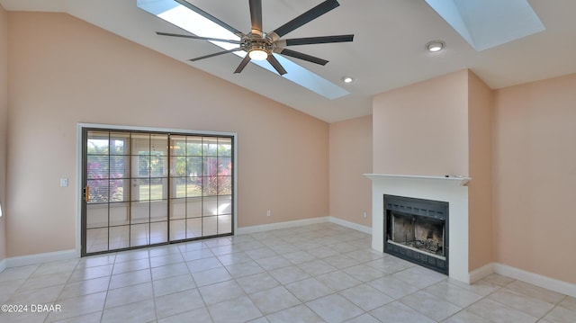 unfurnished living room with lofted ceiling with skylight, a fireplace, baseboards, and ceiling fan