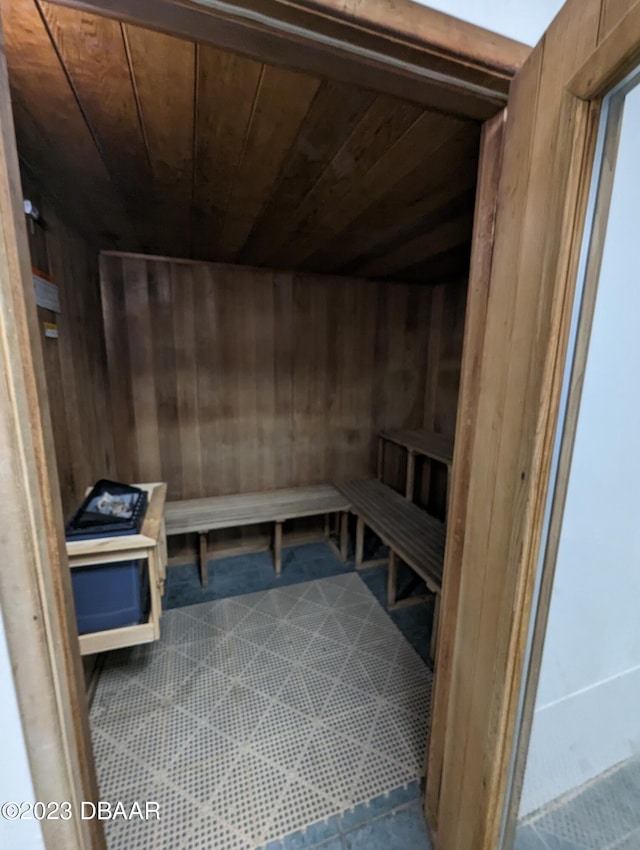 view of sauna / steam room with wooden walls, tile patterned floors, and wooden ceiling