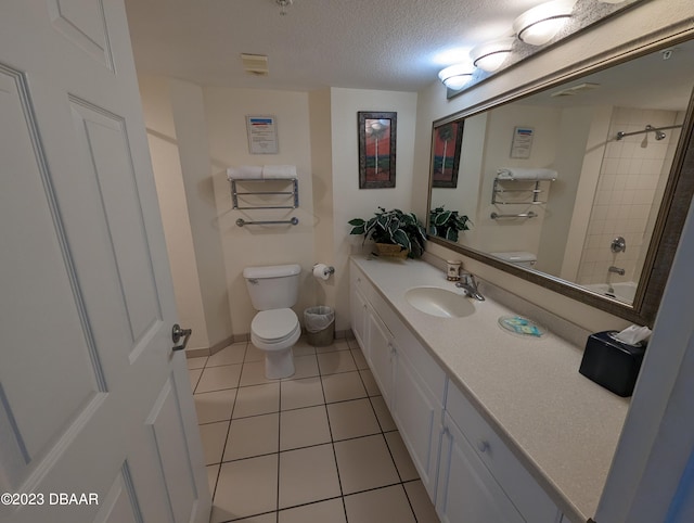 full bathroom with tile patterned floors, vanity, a textured ceiling, toilet, and tiled shower / bath