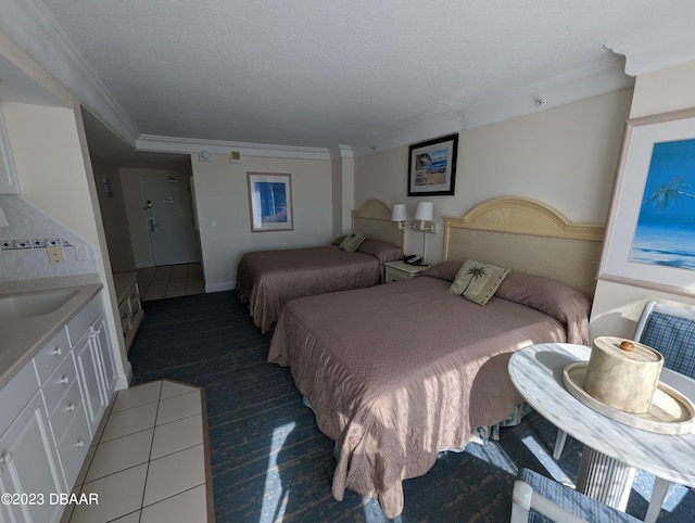 bedroom featuring a textured ceiling, light tile patterned floors, sink, and ornamental molding