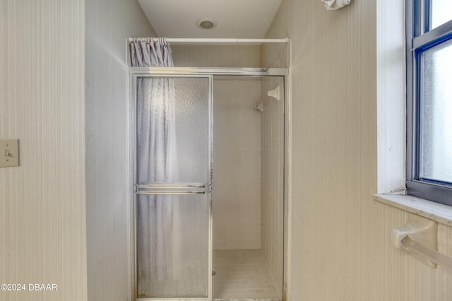 bathroom with a shower with door