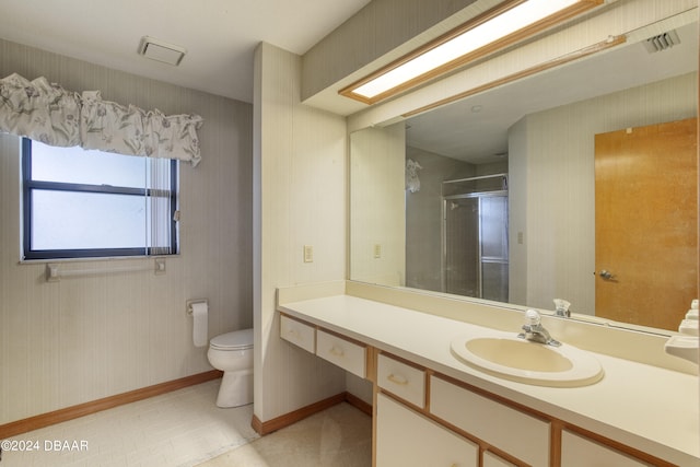 bathroom with toilet, vanity, and an enclosed shower